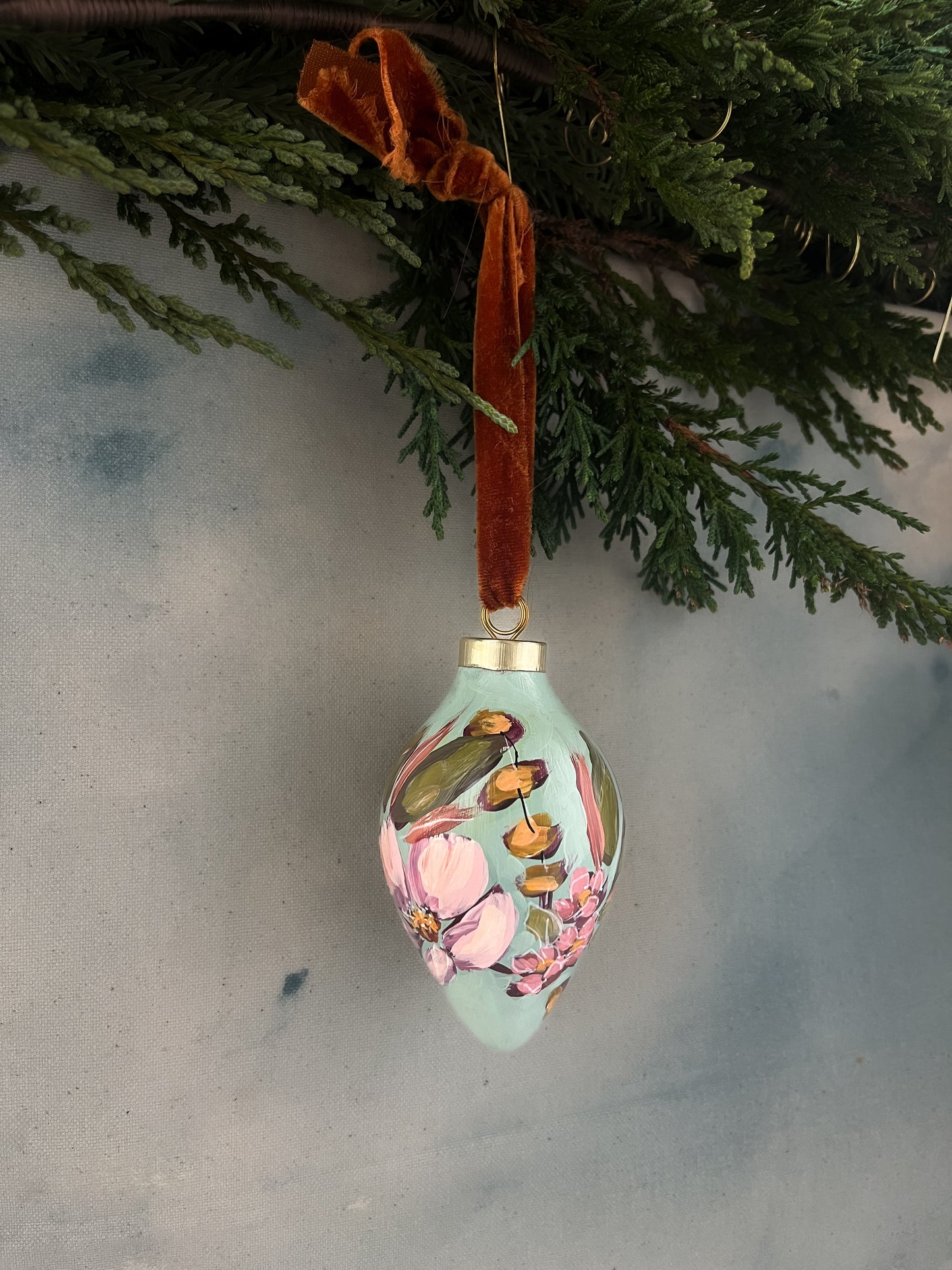 Decorative Christmas ornament with flowers hanging from a tree.